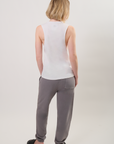 Model wearing a white sleeveless top with a gray BB logo and gray pants on a plain background