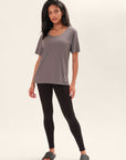 Model wearing a one-size gray t-shirt with a BB logo on the lower left corner and black leggings on a white background