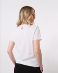 Back-view of a model wearing a white crew neck t-shirt with a reverse BB logo printed in on the back of the neck paired with black pants in front of a white background