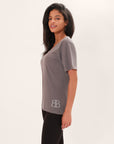 Model wearing a gray t-shirt with a BB logo on the lower left front side in front of a white background